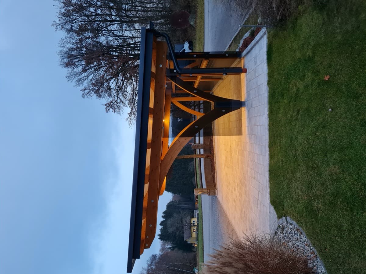 Beleuchteter Carport mit Bogenkonstruktion bei Dämmerung