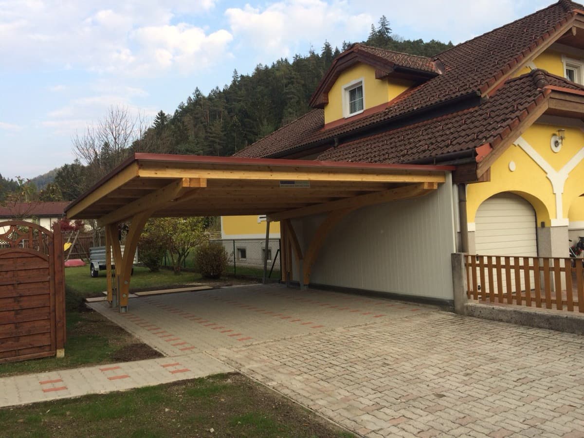 Doppelcarport mit Holzbogen an gelbem Einfamilienhaus
