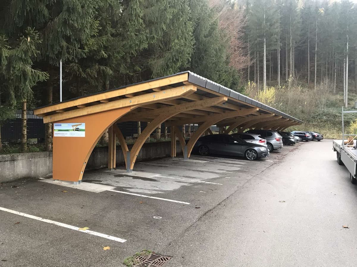 Reihencarport mit Holz-Bogenkonstruktion am Waldrand