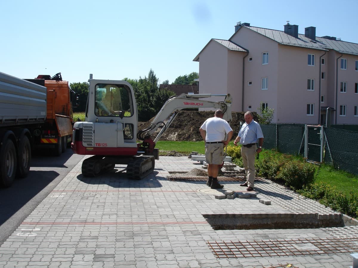 Minibagger beim Aushub für Carport-Fundamente