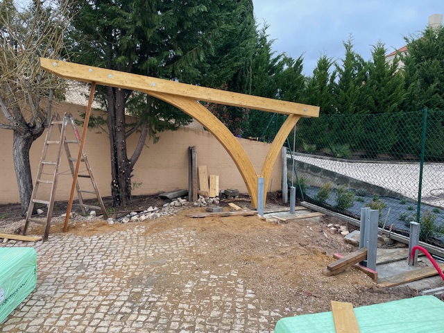 Aufrichten der Bogenstützen für Carport-Konstruktion auf Baustelle