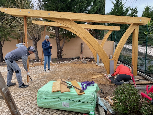 Montageteam beim Ausrichten der Bogenkonstruktion eines Carports