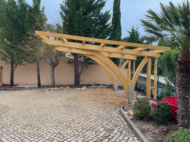 Fertig aufgestellte Carport-Bogenkonstruktion im mediterranen Garten