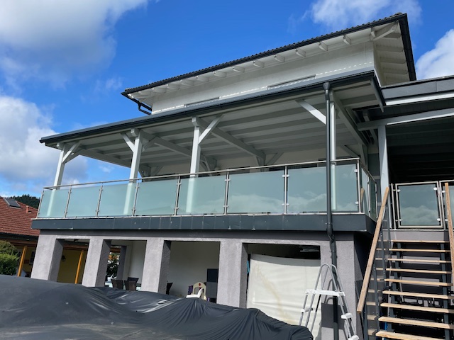 Große weiße Terrassenkonstruktion mit Pultdach und Glasgeländer