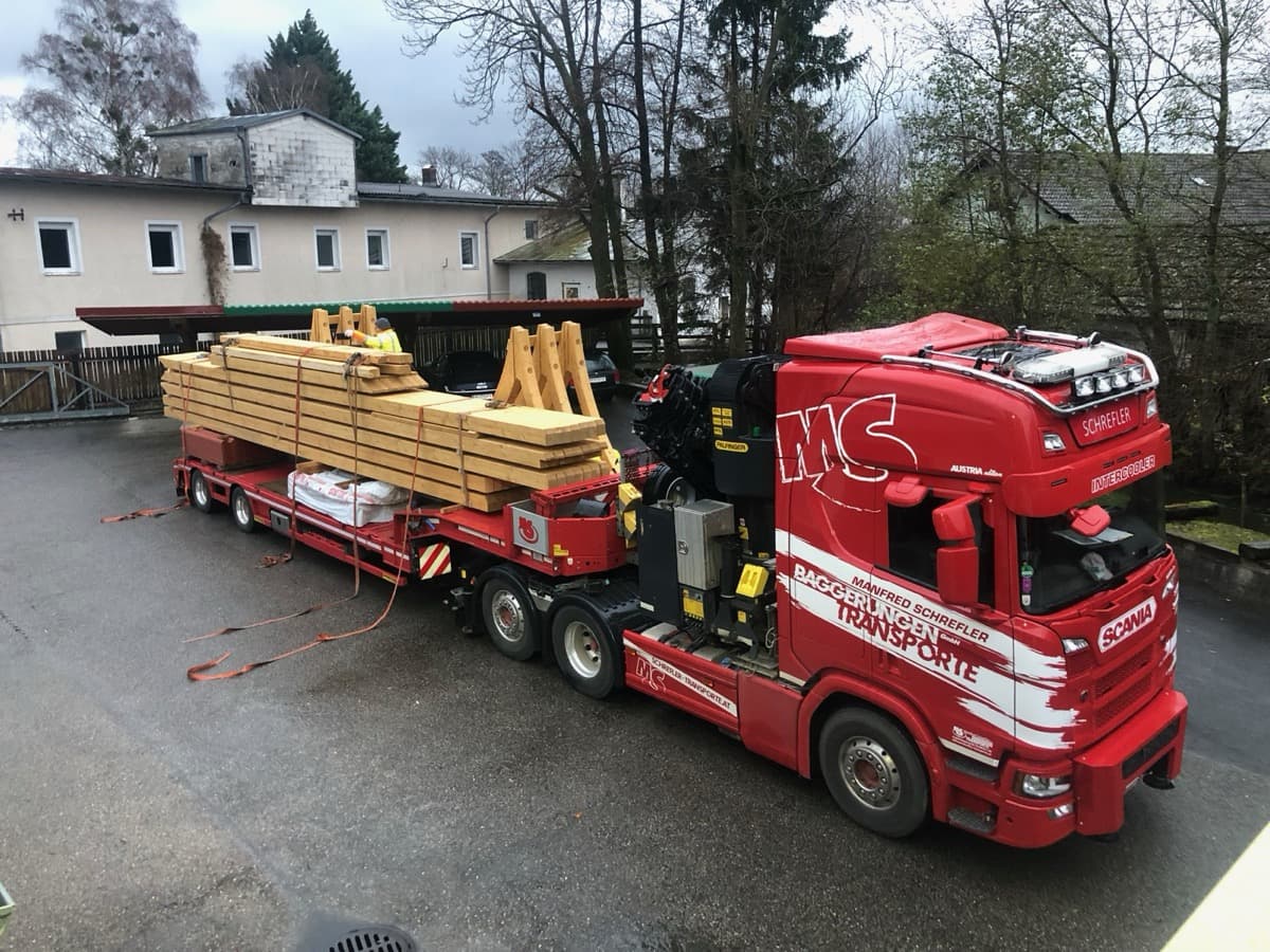 Sattelzug mit Holzbauteilen für Carport-Lieferung