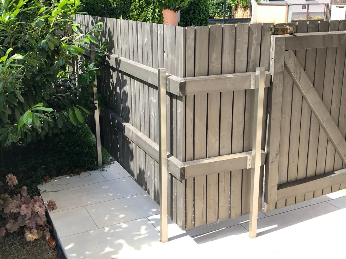 Grauer Holzzaun mit Türelement im Garten